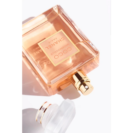 A transparent glass perfume bottle with a gold cap, featuring the Coco Mademoiselle logo. The bottle contains Coco Mademoiselle Eau de Parfum 100ML.