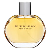 A clear glass perfume bottle with a gold cap, containing Burberry For Women Eau de Parfum. The bottle is sitting on a white background.