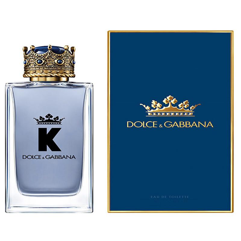 A sleek, masculine glass perfume bottle containing Dolce & Gabbana K Eau de Toilette. The bottle features a bold, modern design with a dark blue hue, suggesting a sophisticated and masculine fragrance